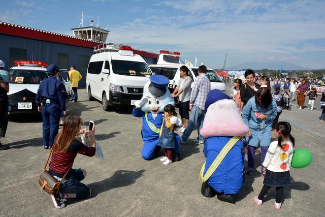 青とピンクの富士山を模した警察のゆるキャラと小さな女の子が写真と撮っている写真