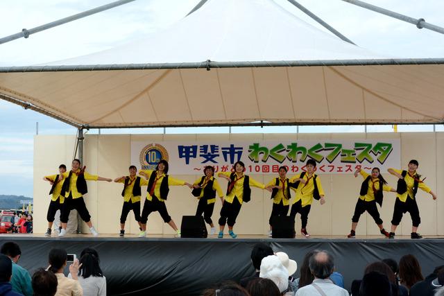 日本航空学園の学生が黄色と黒の衣装を着て踊っている写真