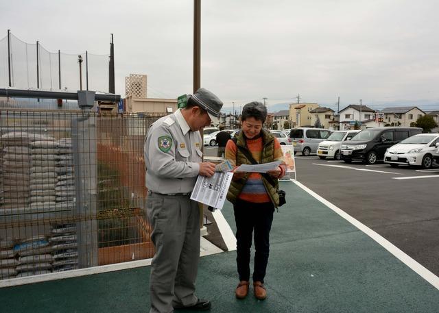 資料を持って市民に説明する消防署の人の写真