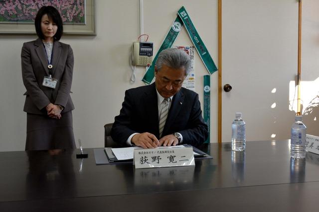 (写真)調印する荻野寛二様