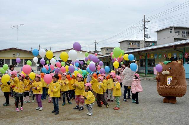 園庭で風船を持つ園児たちの写真