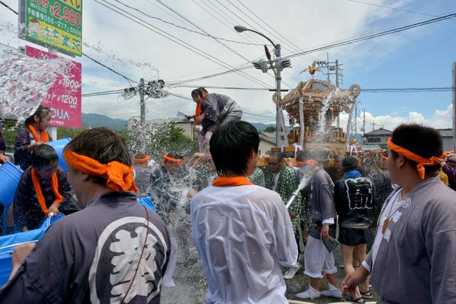 神輿にホースで水をかけている写真