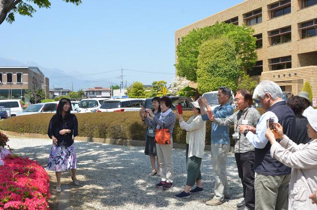 屋外に移動し、花にカメラやスマートフォンを向ける参加者たちの写真