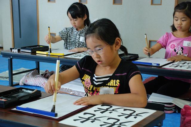 女の子が光という字を書いている写真