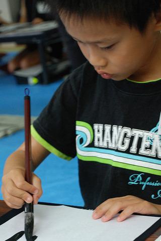 男の子が小さく字を書いている写真