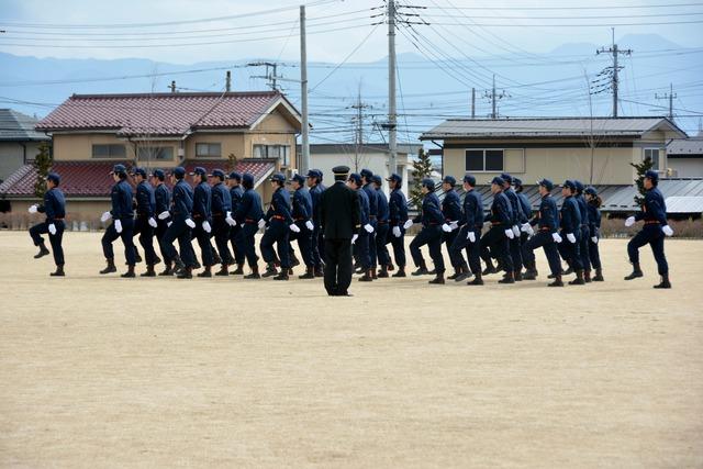 訓練礼式で消防団員が整列し行進している様子の写真