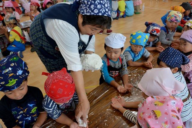 (写真)並んだ園児たちに生地を分ける様子