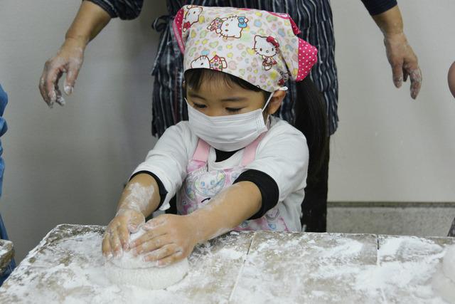 小さな子どもが餅をまるめている写真