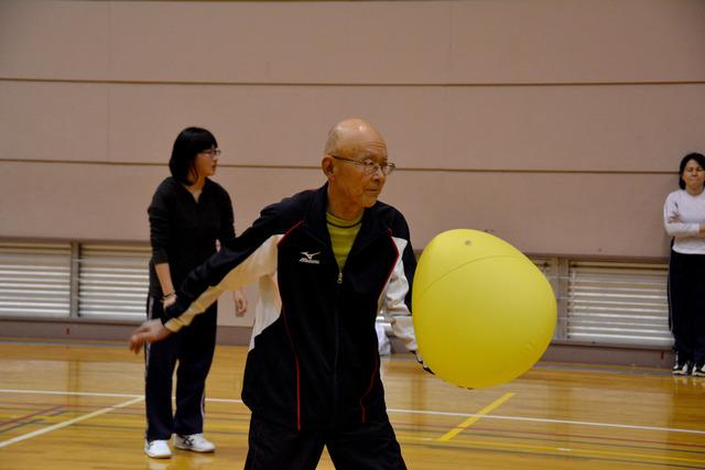 ボールを投げようとする年配の男性の写真