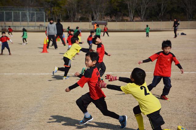 (写真)両手でタッチをする子どもと逃げる子ども(1枚目)