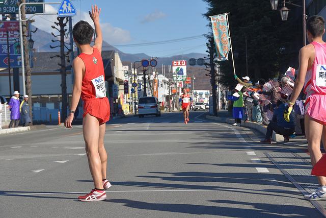 (写真)3区スタート地点で手を挙げ、河口英史選手を待つ黒木瞬選手