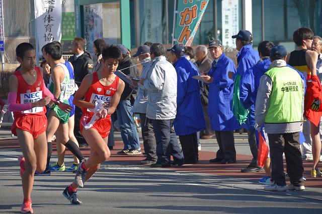 (写真)3区スタート地点で清水陽斗選手から小林優真選手に襷を渡す