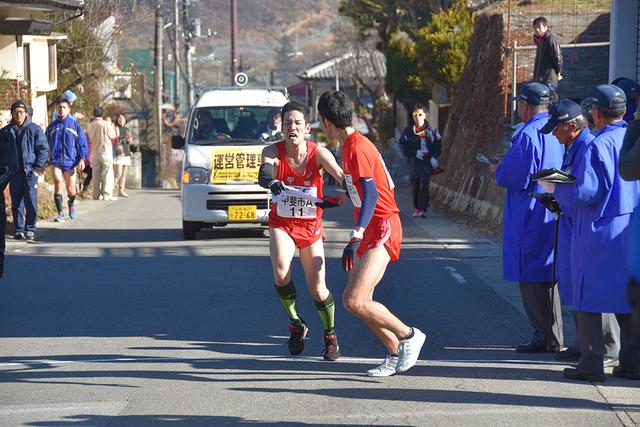 (写真)6区スタート地点で上田聖斗選手から大沢正和選手に襷を渡す