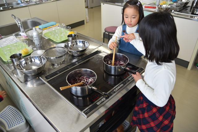 ムラサキキャベツを鍋で茹でる子供たちの写真