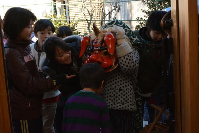 獅子舞の周りに子どもが集まっている写真