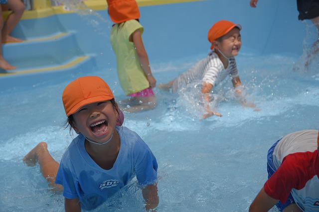 プールで笑顔で遊ぶ子どもたちの写真