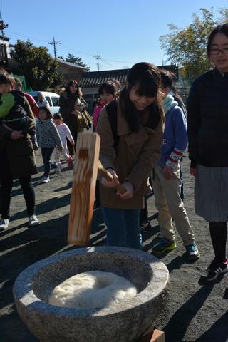 杵で餅をつく女の子の写真