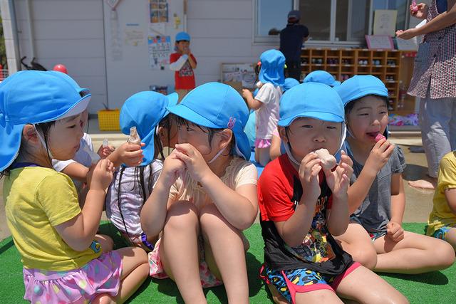 濡れたままアイスを食べる子どもたちの写真