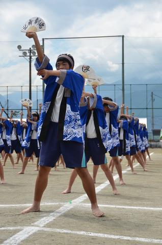 青い法被を着てセンスを持って踊る生徒たちの写真