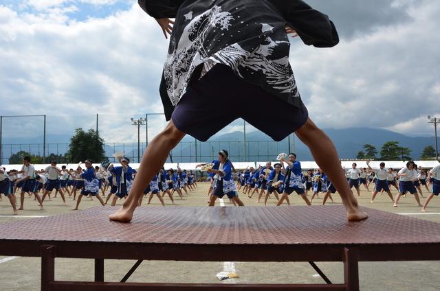 運動場いっぱいに並んでソーラン節を踊る生徒たちの写真