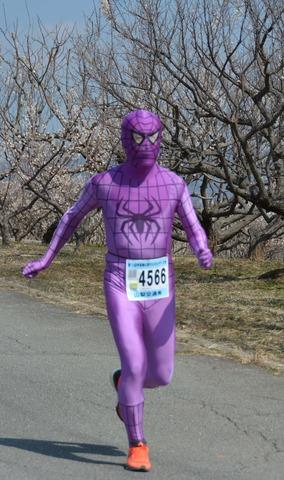 (写真)紫色の全身タイツを着て走るランナー