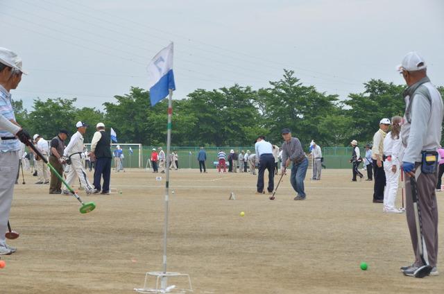 双葉スポーツ公園で沢山の年配の男性がグランドゴルフをしている写真