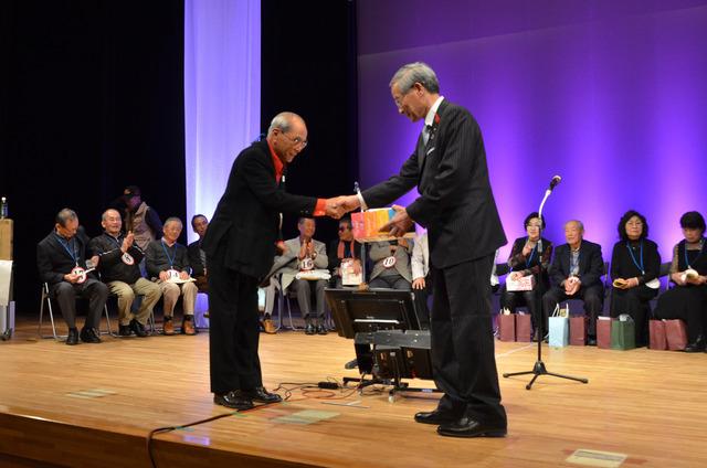 (写真)笑顔で表彰を受ける優勝した代表者の渡邉健二さん