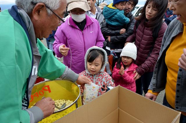 (写真)ポップコーンをもらい喜ぶ子ども