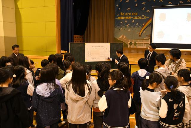 明るい選挙出前授業 子供達が立って、ホワイトボードを見ている写真