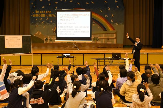 明るい選挙出前授業 子供達と先生が手を挙げている写真