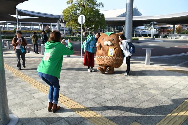 甲斐市営業部長のやはたいぬが参加者を出迎え、記念撮影を撮っている写真1