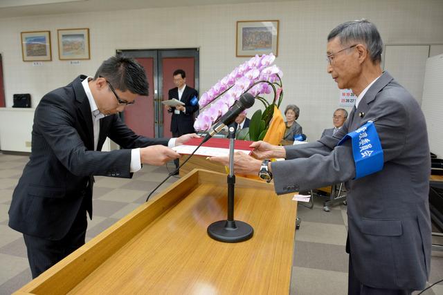 甲斐市役所にて堀内克一選挙管理委員会委員長から横山洋介氏へ当選証書が手渡されている写真