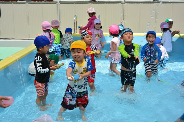 笑顔でプールで遊ぶ子供たちの写真