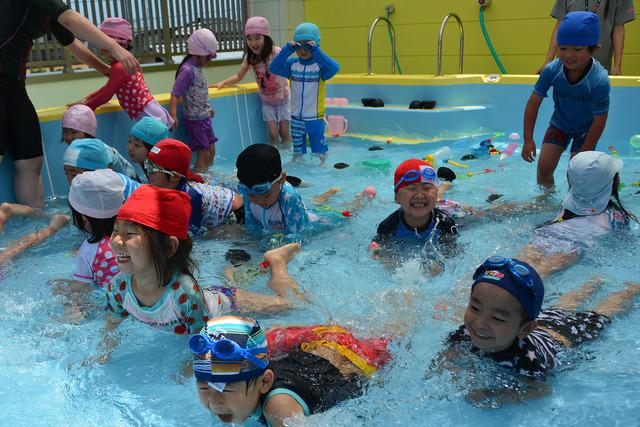 笑顔でプールで遊ぶ子供たちの写真
