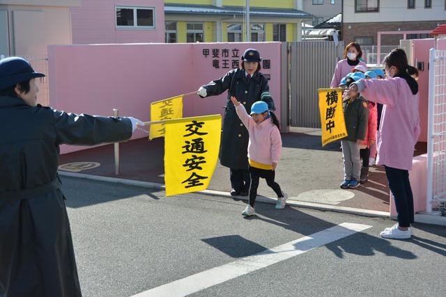 竜王西保育園の門の前で女子園児が道路を横断している写真