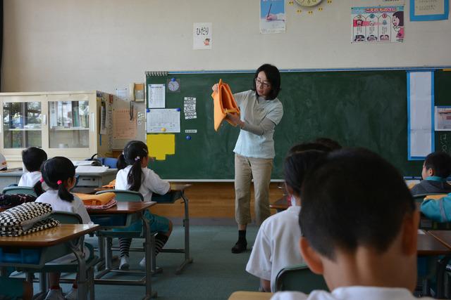 教室で防空頭巾の説明をする先生の写真