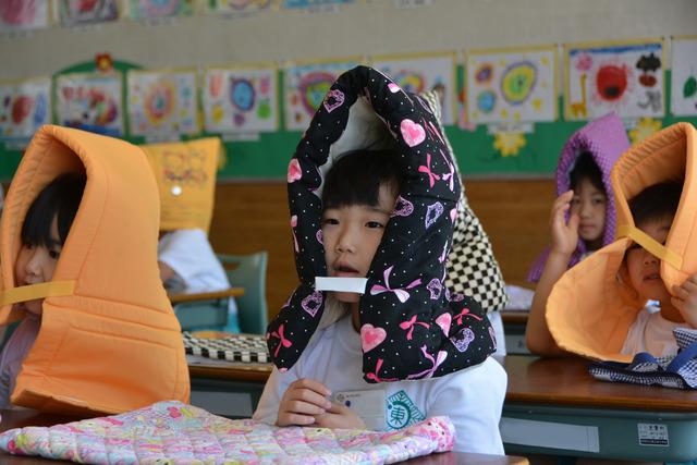 防空頭巾を被っている児童たちの写真