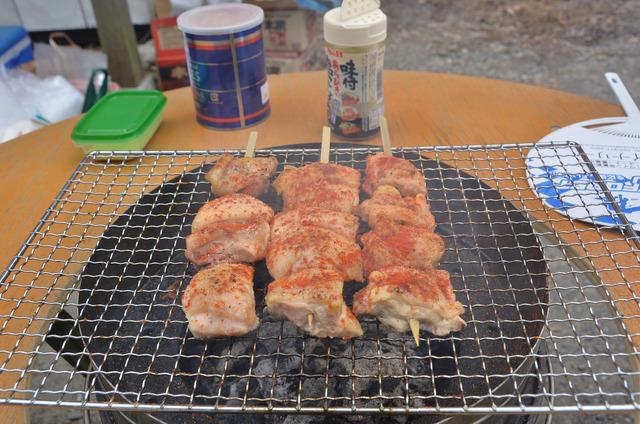 網の上で焼かれている串焼きの写真