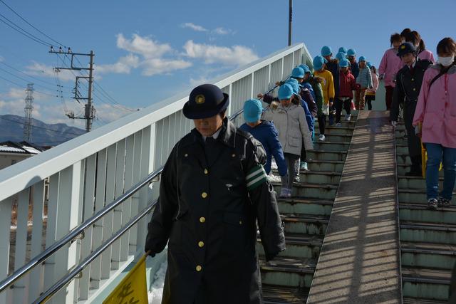 婦警のあとに続き園児たちが歩道橋を下っている写真