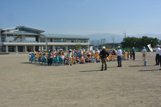 防災頭巾を被り運動場で整列する児童たちの写真