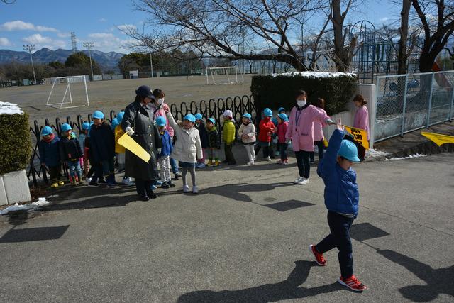 竜王北小学校前で児童たちが手を挙げ横断している写真