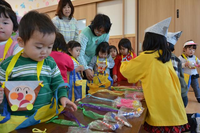 並べられた商品を見る園児と店員役の園児の写真