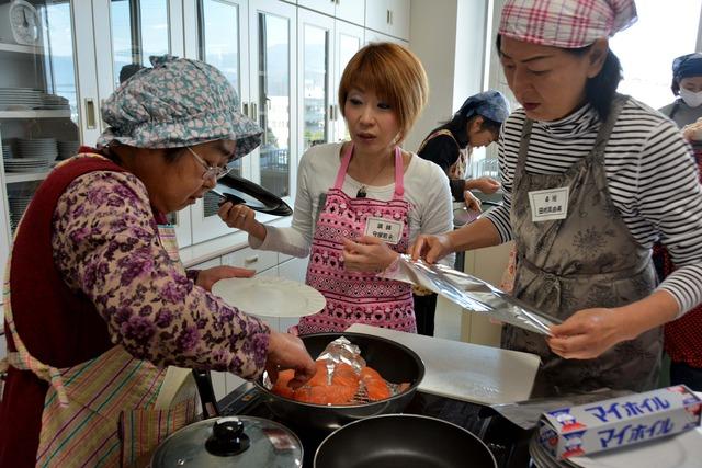 先生に教わりながら、料理をする参加者たちの写真