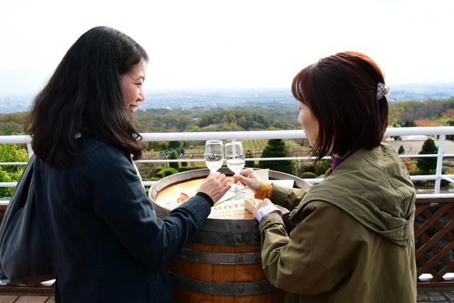 女の人2人がワインを持って 乾杯している写真