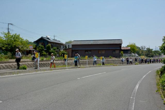 歩道を1列になって畠中さんと参加者が歩いている写真