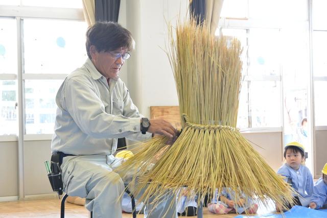 藁を編んでいる小澤さんの写真