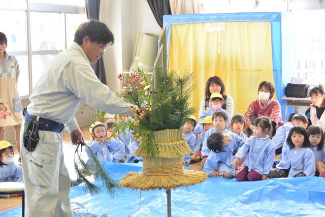 松や南天で門松の飾り付けを行う小澤さんの写真