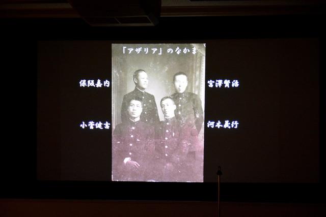 スクリーンに宮澤賢治と仲間の写真が映されている写真