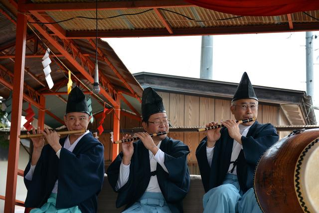 烏帽子をかぶって笛を吹く三人の男性の写真