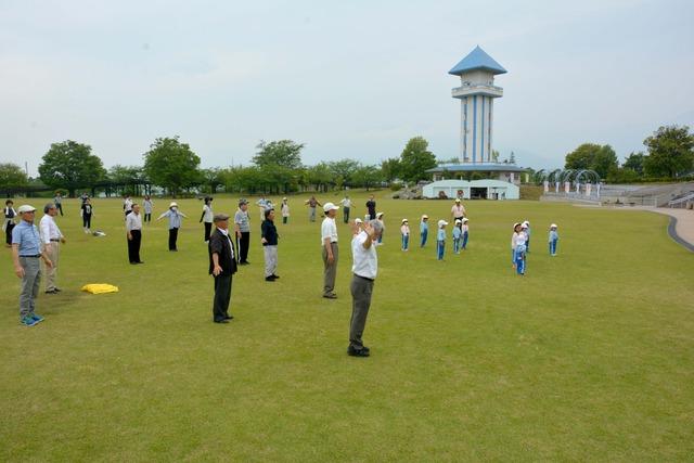 芝生の広場に集まった大人や園児たちの写真